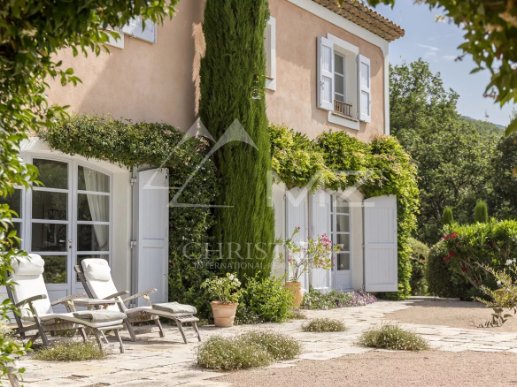 Propriété de charme avec terrasse et chaises longues, entourée de verdure à Saint-Vallier-de-Thiey.