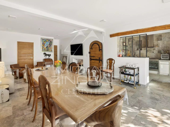 Intérieur d'une magnanerie rénovée avec salle à manger et cuisine ouverte.