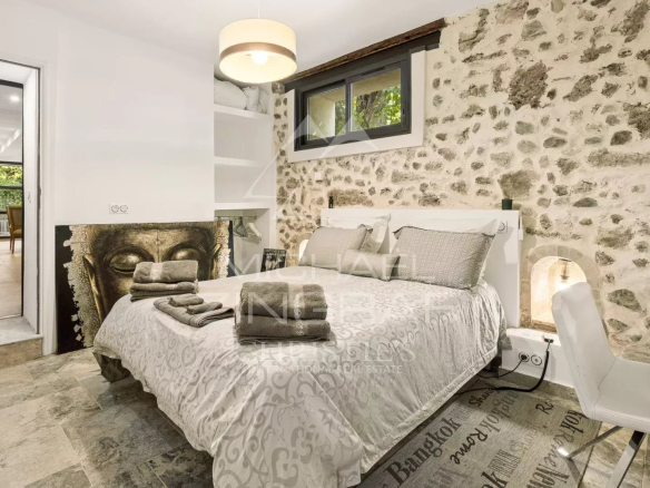 Chambre d'une magnanerie du 18ème siècle avec murs en pierre et lit double.