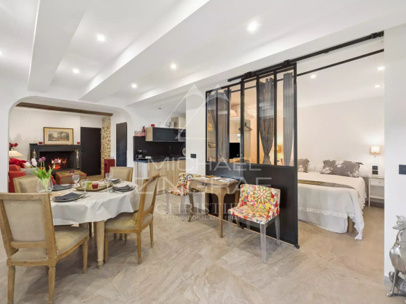 Intérieur d'un appartement avec salle à manger, cuisine équipée et chambre séparée dans une demeure de caractère.
