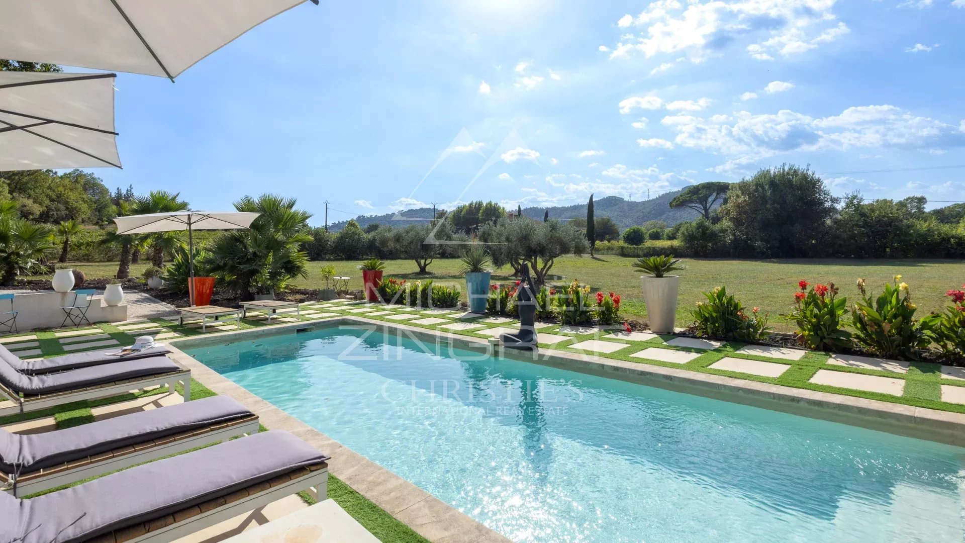 Demeure avec piscine et vue sur les vignobles Piscine entourée de chaises longues et de plantes, avec vue sur un terrain verdoyant.