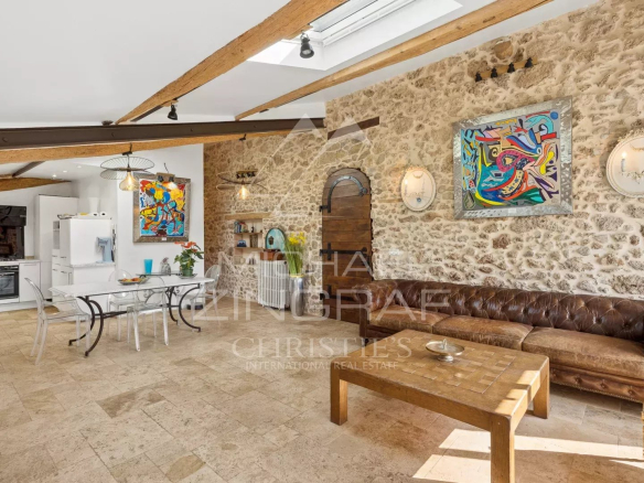 Intérieur d'une magnanerie du 18ème siècle avec murs en pierre, salon et cuisine équipée.