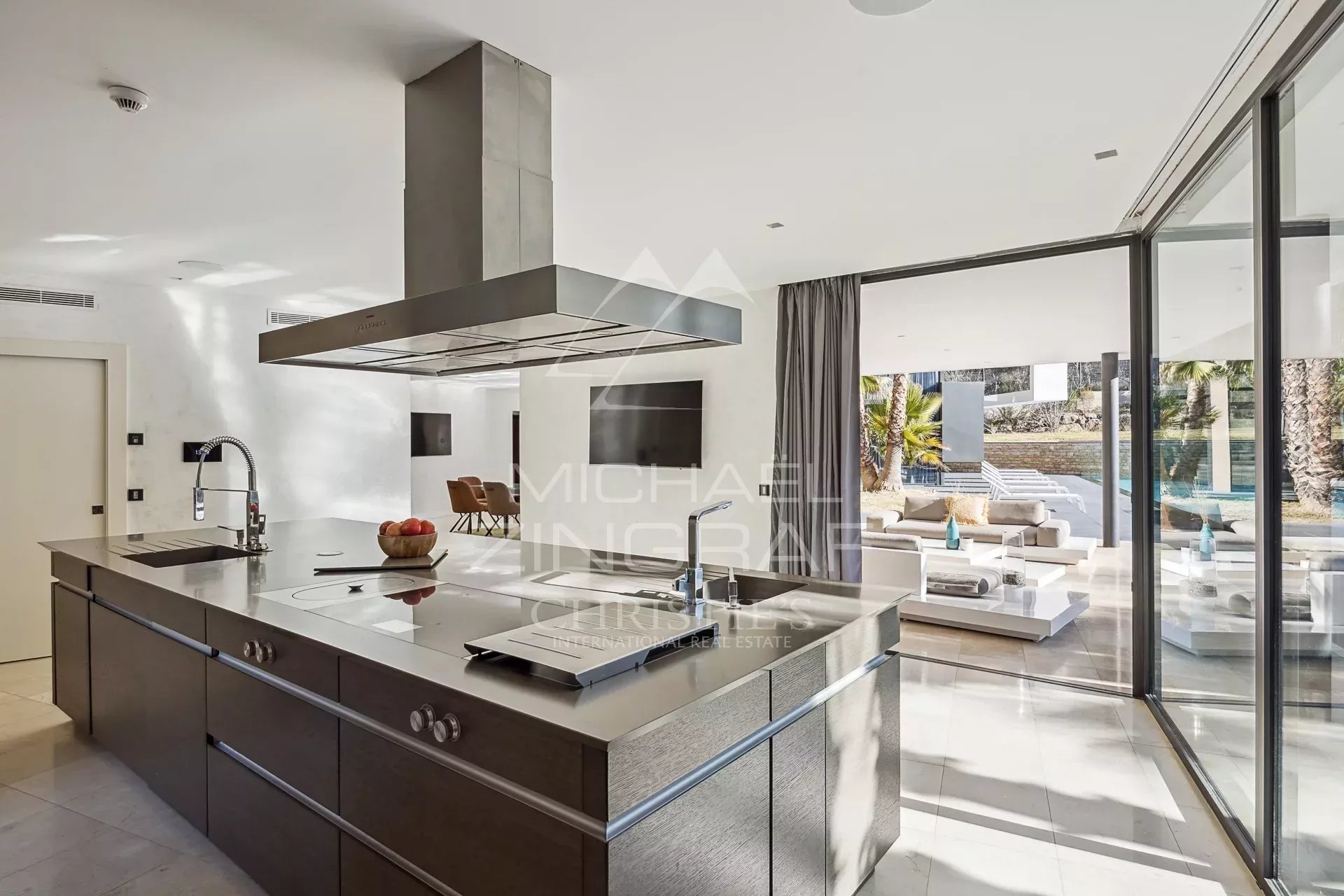 Cuisine contemporaine de villa à Fayence Cuisine moderne et spacieuse avec îlot central et baies vitrées donnant sur l'extérieur.