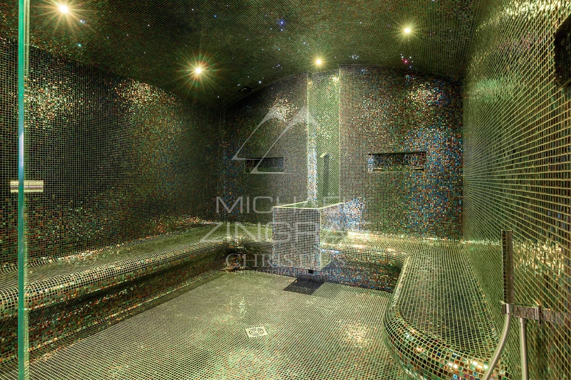 Hammam contemporain Intérieur d'un hammam décoré de mosaïques colorées, avec bancs et éclairage doux.