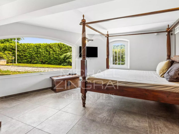 Spacious room with a four-poster bed and a view of the garden.