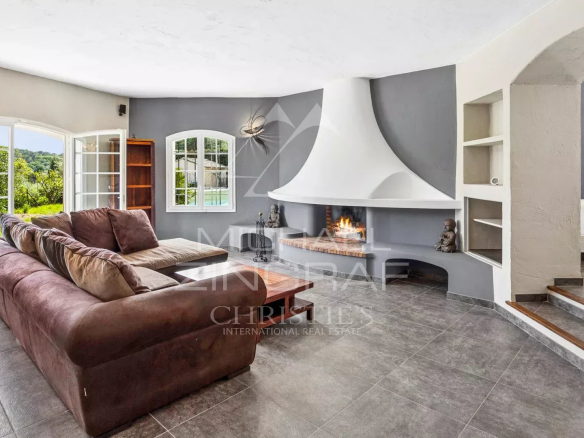 Bright living room in a villa with fireplace and access to the garden.