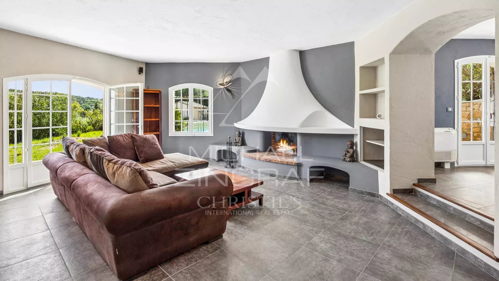 Bright living room in a villa with fireplace and access to the garden.