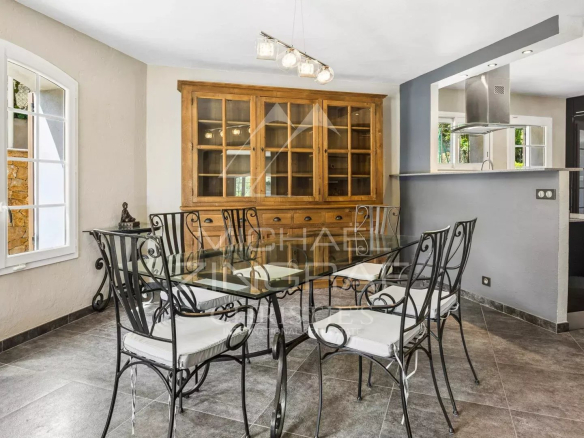 Dining room with glass table and wrought iron chairs in a family villa.