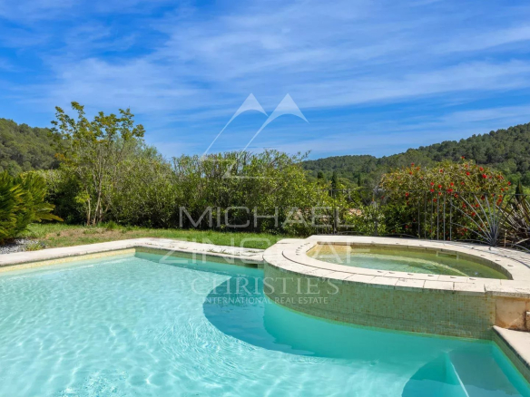 Swimming pool and jacuzzi of a family villa in Opio, surrounded by greenery.