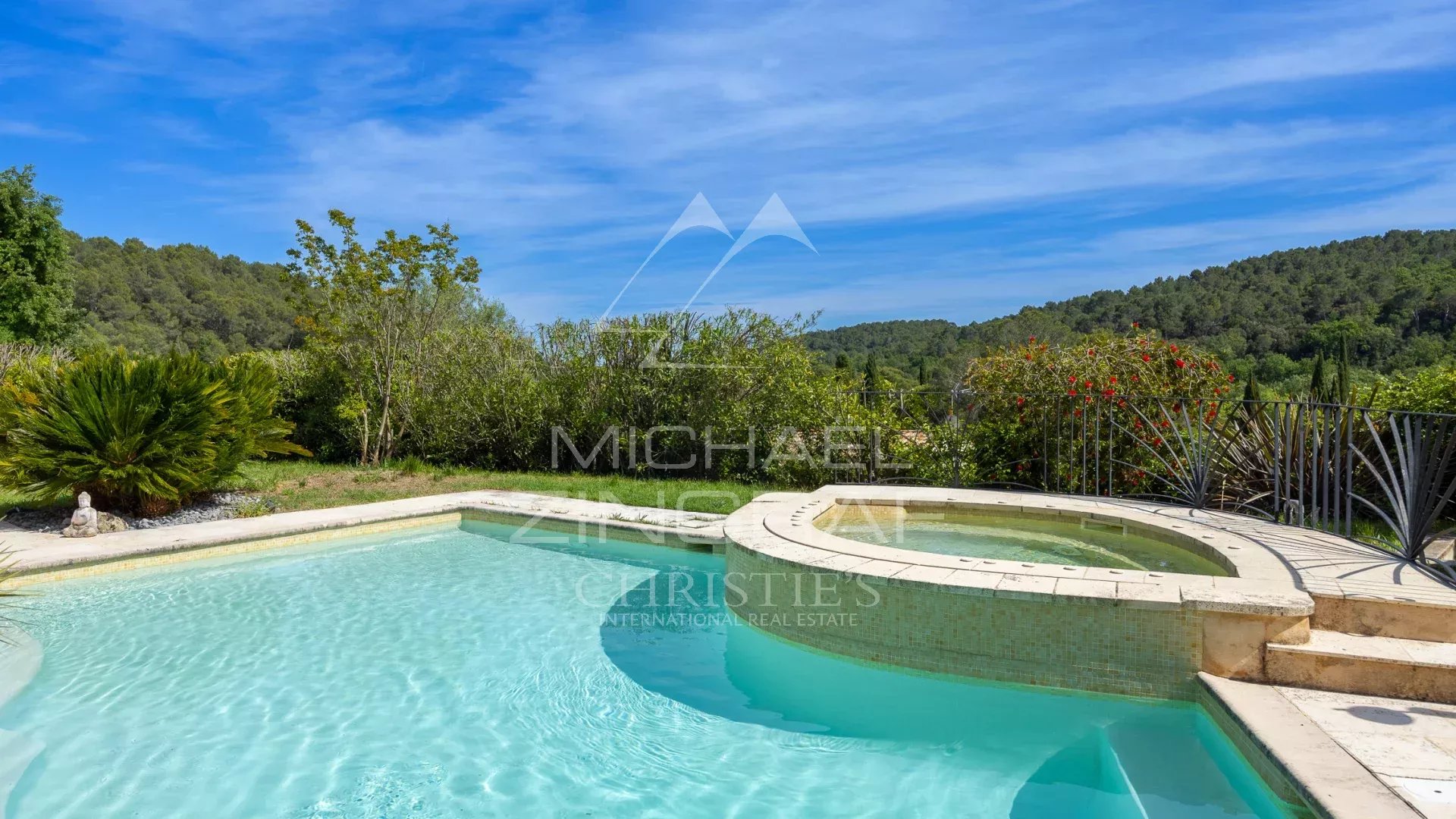 Swimming pool and jacuzzi of a family villa in Opio, surrounded by greenery.
