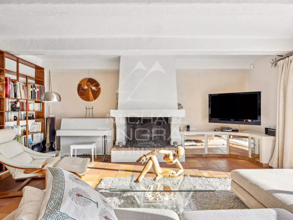 Intérieur d'une villa provençale avec salon lumineux et cheminée.