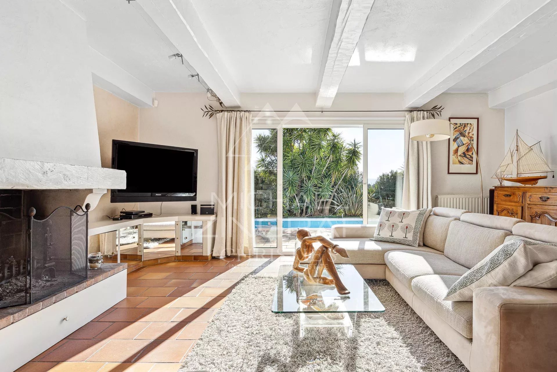Intérieur d’une villa provençale Intérieur lumineux d'une villa provençale avec salon, cheminée et vue sur jardin.