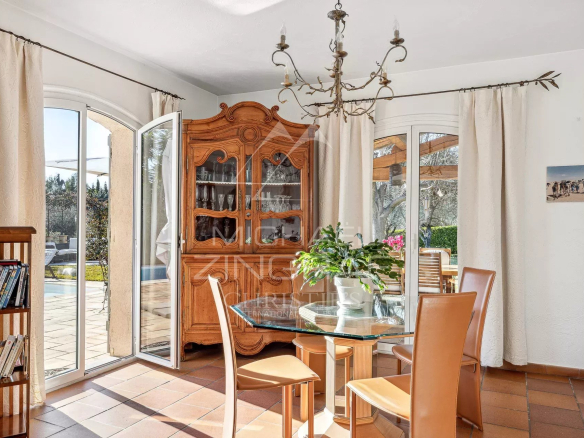 Intérieur d'une villa provençale avec salle à manger lumineuse et bibliothèque.