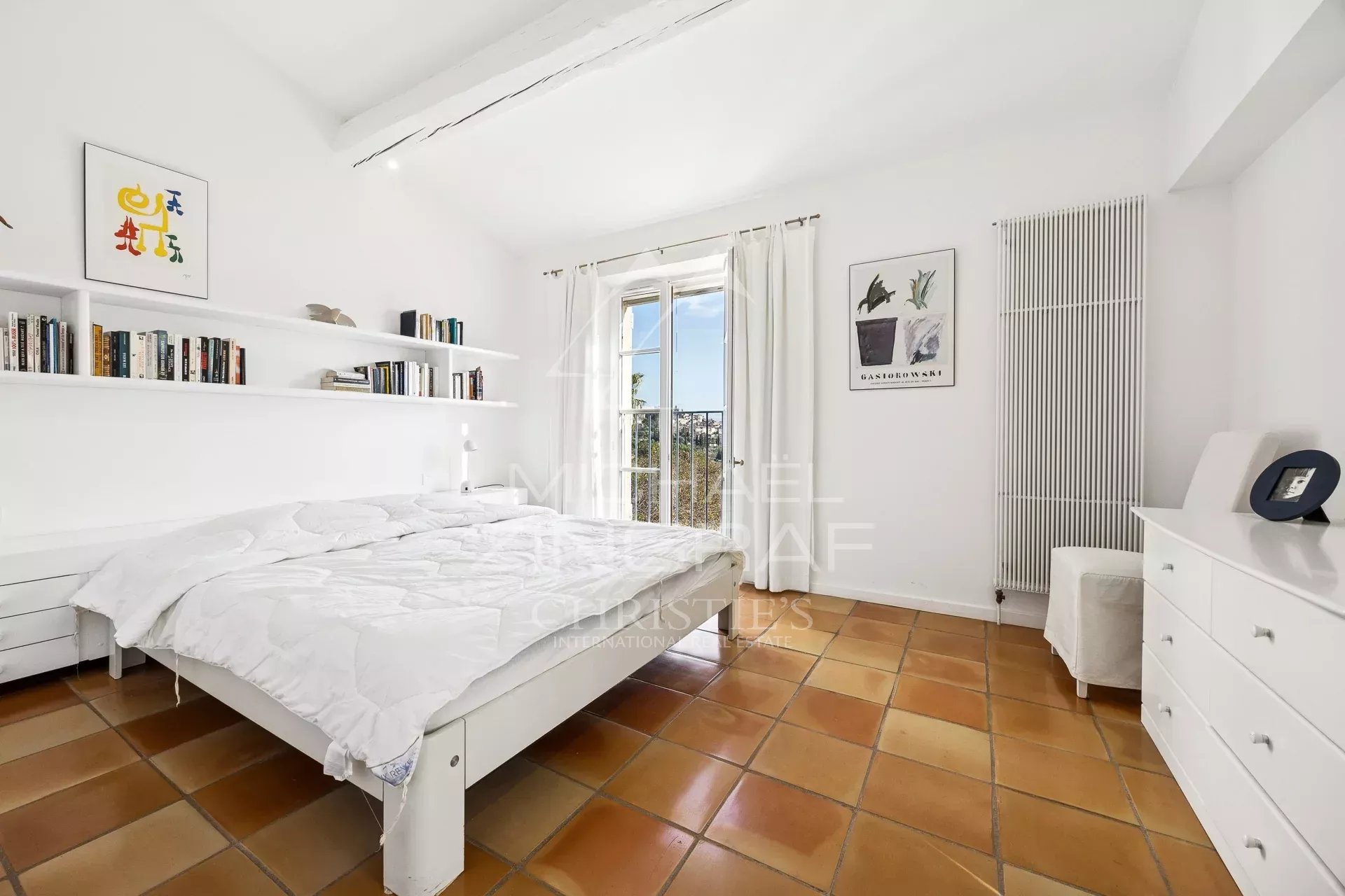 Chambre de villa à Fayence Chambre lumineuse avec lit double et vue sur l'extérieur, décorée simplement.