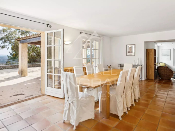 Intérieur d'une villa à Fayence avec une grande table à manger et des portes-fenêtres donnant sur une terrasse.