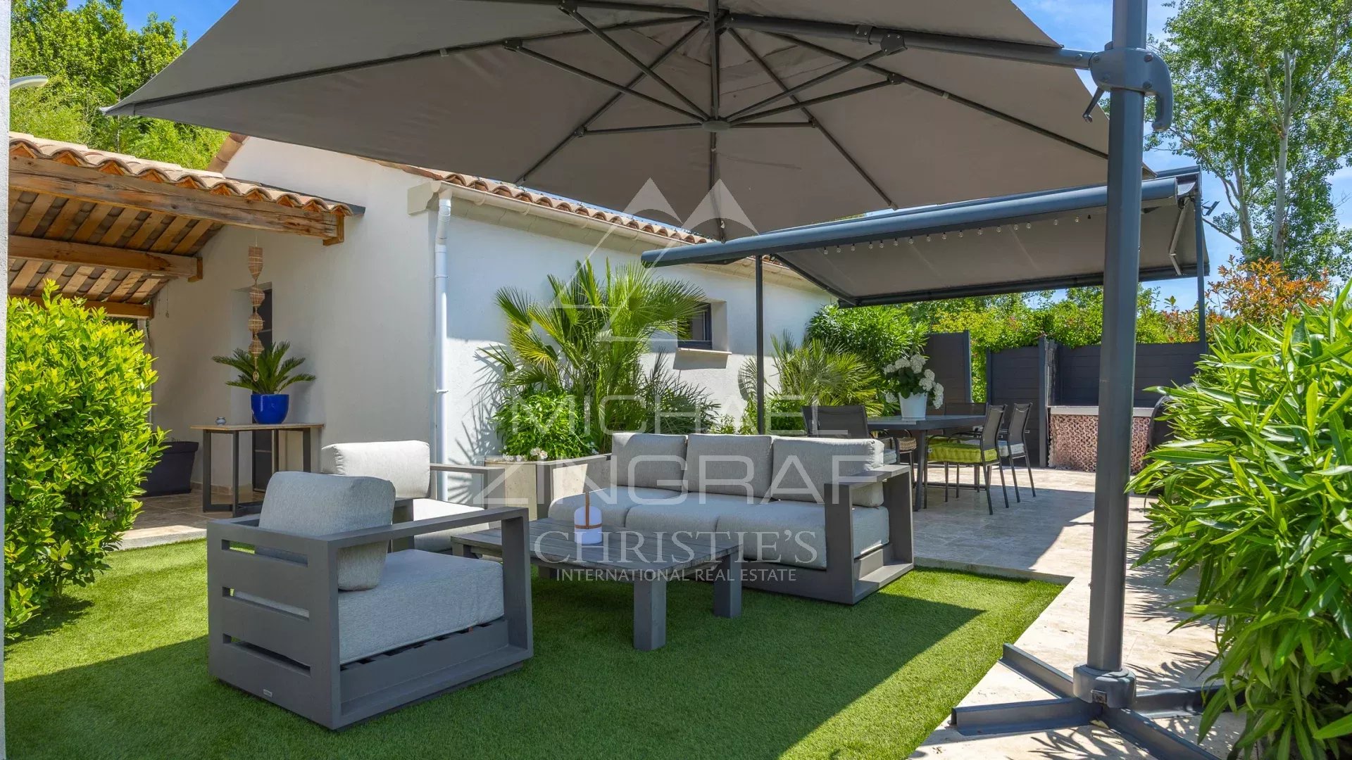 Terrasse d’une villa moderne à Grasse Terrasse d'une villa moderne à Grasse avec mobilier de jardin et parasol.