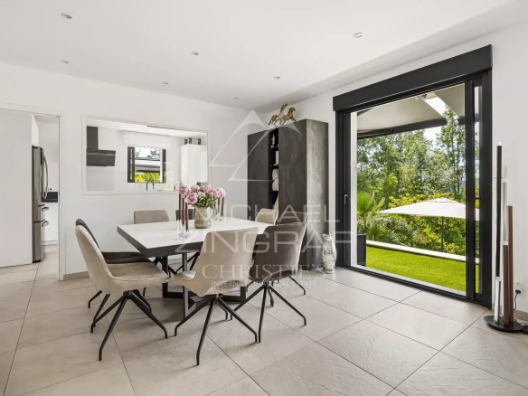 Intérieur d'une villa moderne avec salle à manger et vue sur le jardin à Grasse.