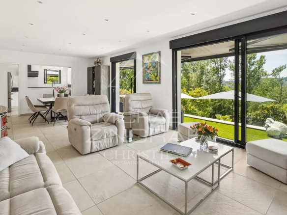 Intérieur d'une villa moderne à Grasse avec un salon lumineux et un accès au jardin.