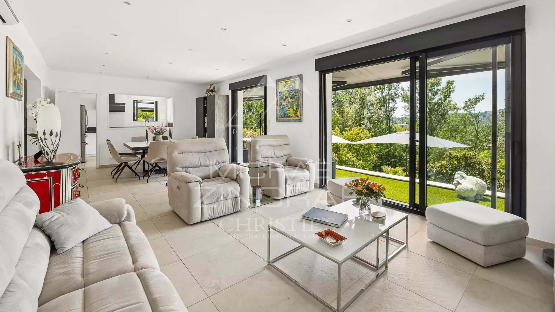 Salon d’une villa moderne à Grasse Intérieur d'une villa moderne à Grasse avec un salon lumineux et un accès au jardin.