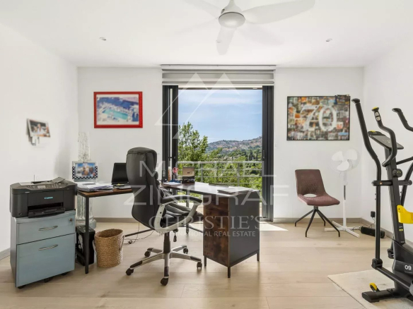 Intérieur d'une villa moderne à Grasse avec bureau et vue sur la campagne.