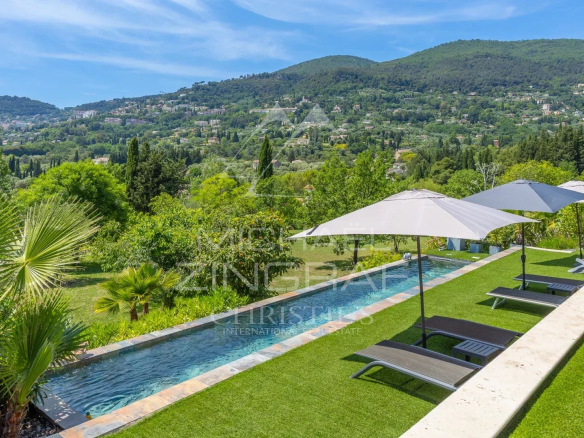 Vue d'une villa moderne avec piscine et parasols, entourée de verdure à Grasse.
