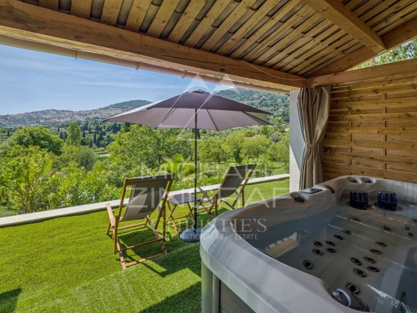 Terrasse avec jacuzzi et chaises longues, vue sur la campagne à Grasse.