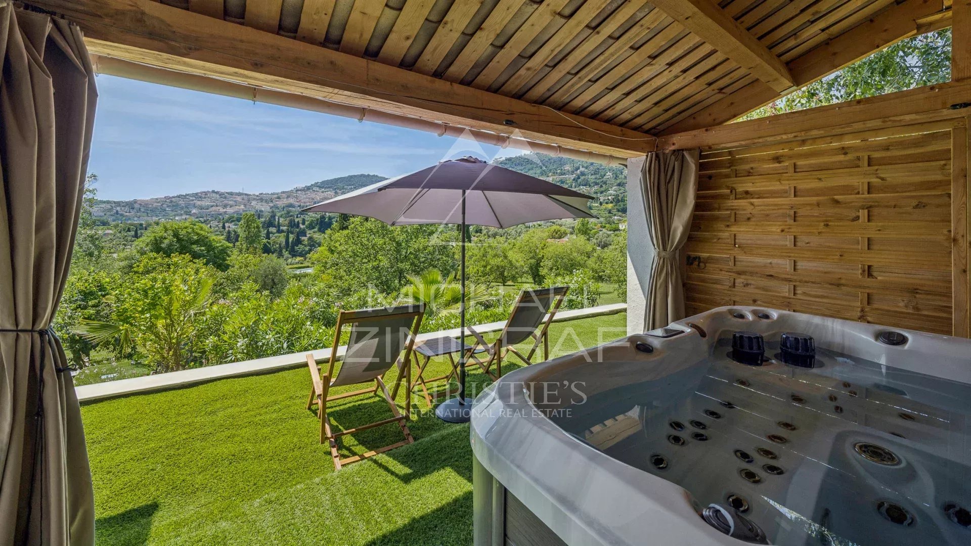 Terrasse de villa moderne à Grasse Terrasse avec jacuzzi et chaises longues, vue sur la campagne à Grasse.