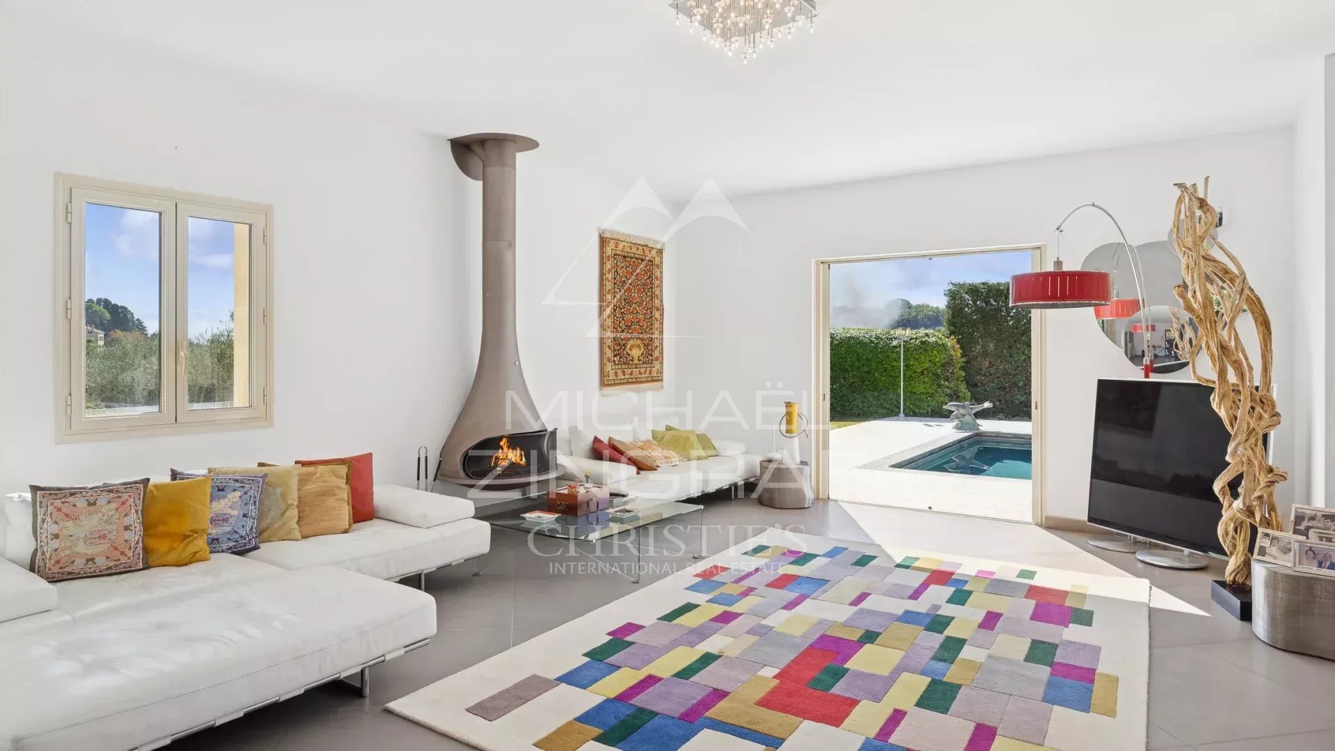 Intérieur de villa à Grasse Intérieur d'une villa moderne avec cheminée et accès à la piscine, décoré avec un tapis coloré.