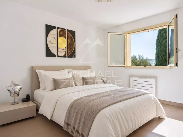 Chambre lumineuse d'une villa à Grasse avec fenêtre ouverte et décoration moderne.