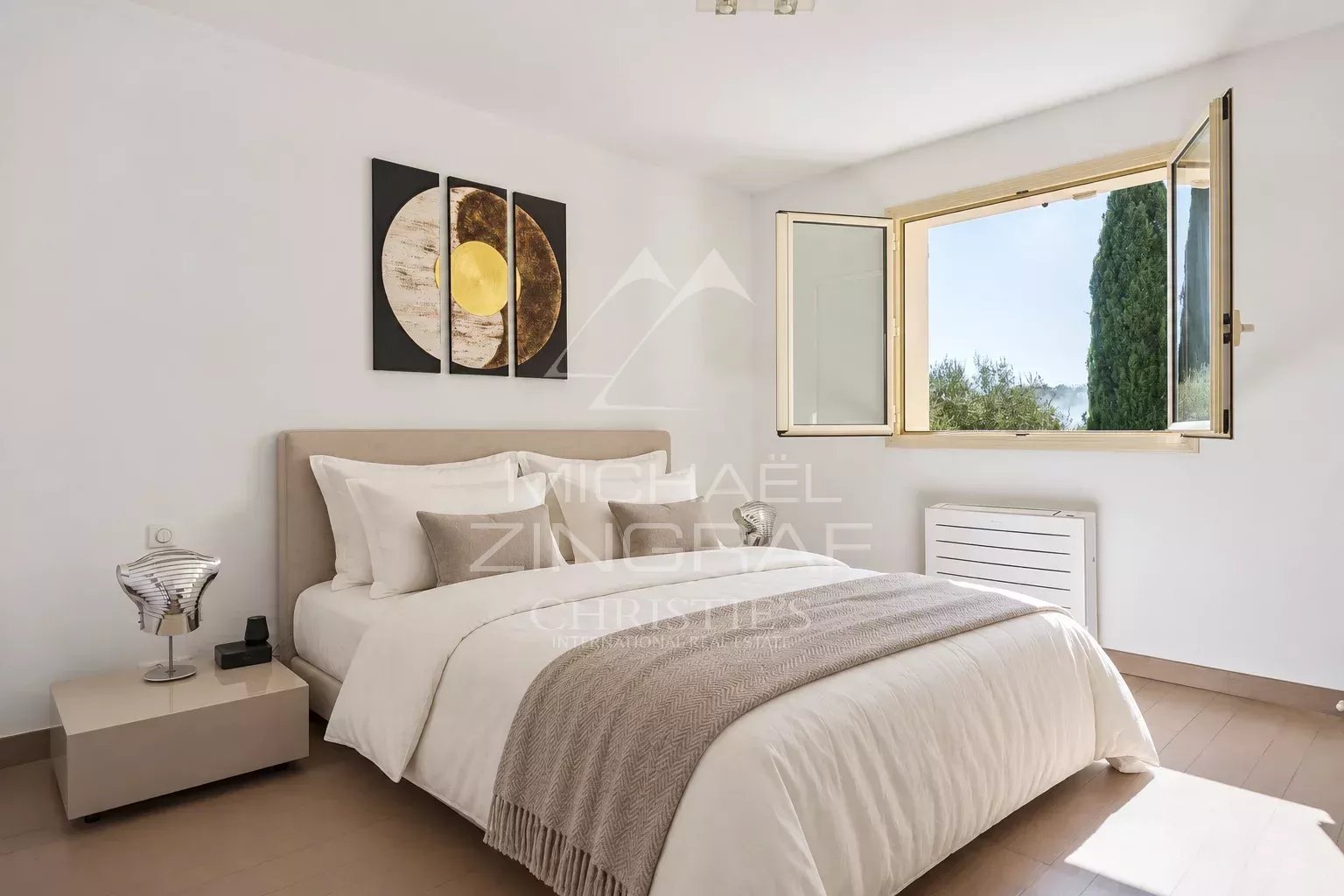Chambre d’une villa à Grasse Chambre lumineuse d'une villa à Grasse avec fenêtre ouverte et décoration moderne.