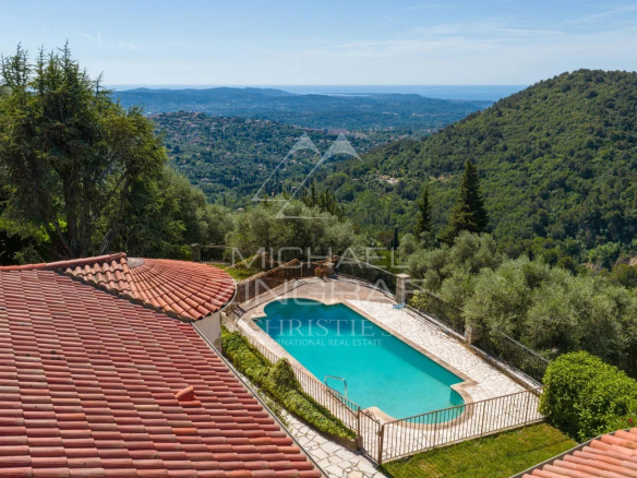 Vue d'une villa provençale avec piscine et collines environnantes à Grasse.