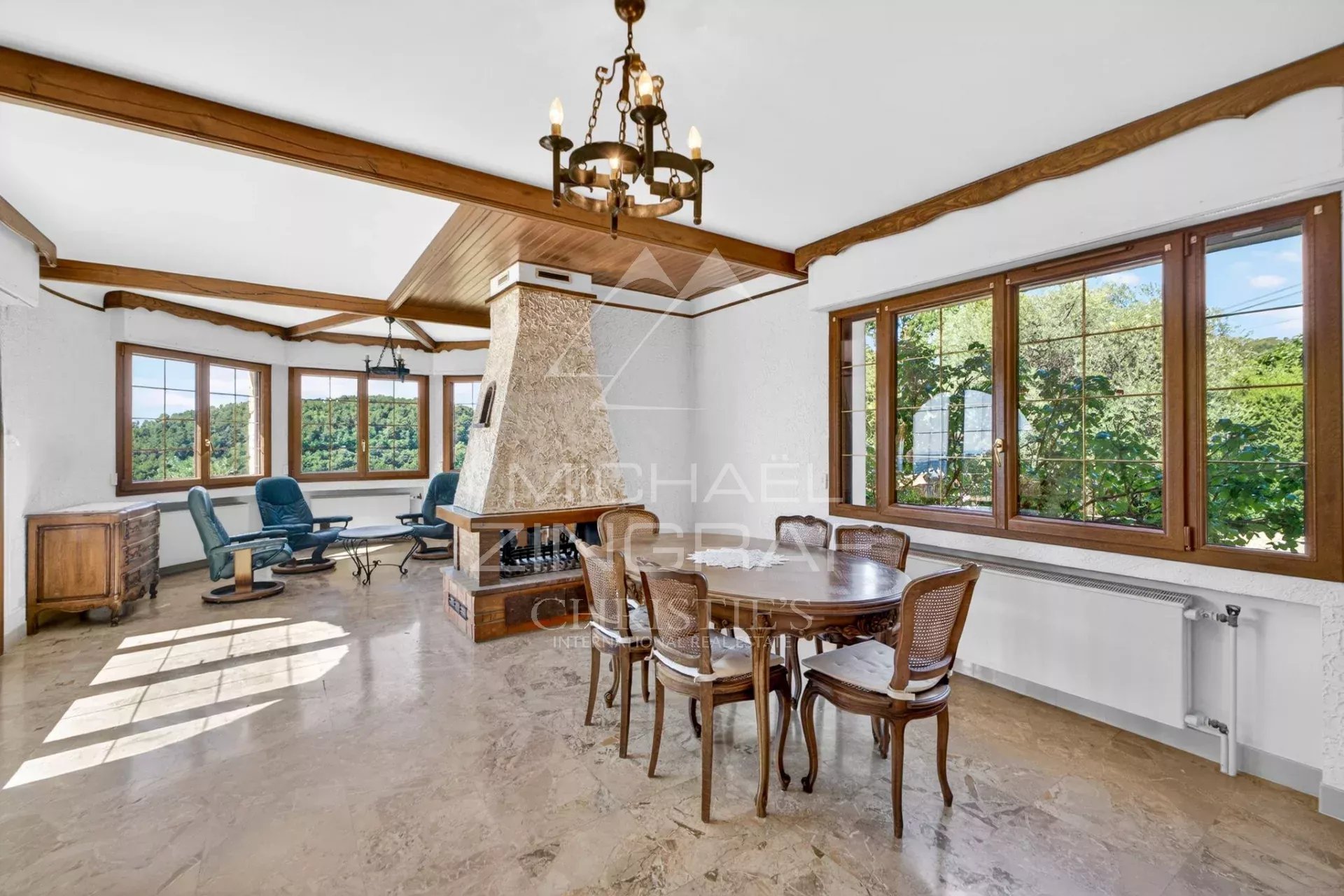 Intérieur d’une villa provençale à Grasse Intérieur d'une villa provençale avec salon lumineux et salle à manger, vue sur la nature.