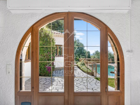 Vue intérieure d'une villa provençale avec fenêtres en arc et accès à l'extérieur.