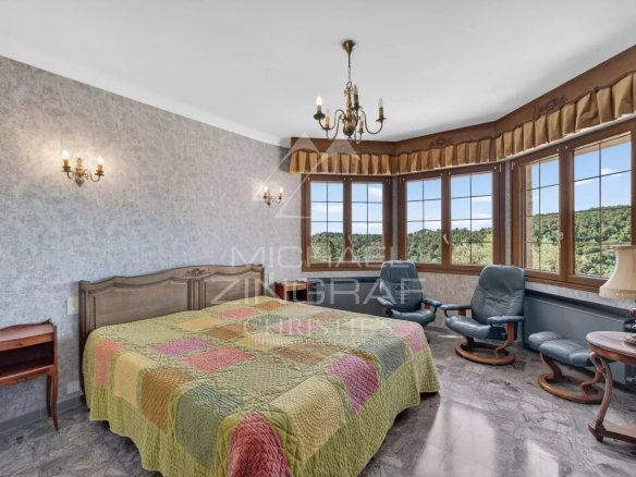 Chambre d'une villa provençale à Grasse avec vue sur les collines.