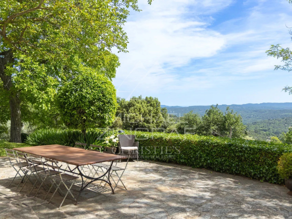 Terrasse avec table en métal et vue sur la campagne verdoyante à Fayence.