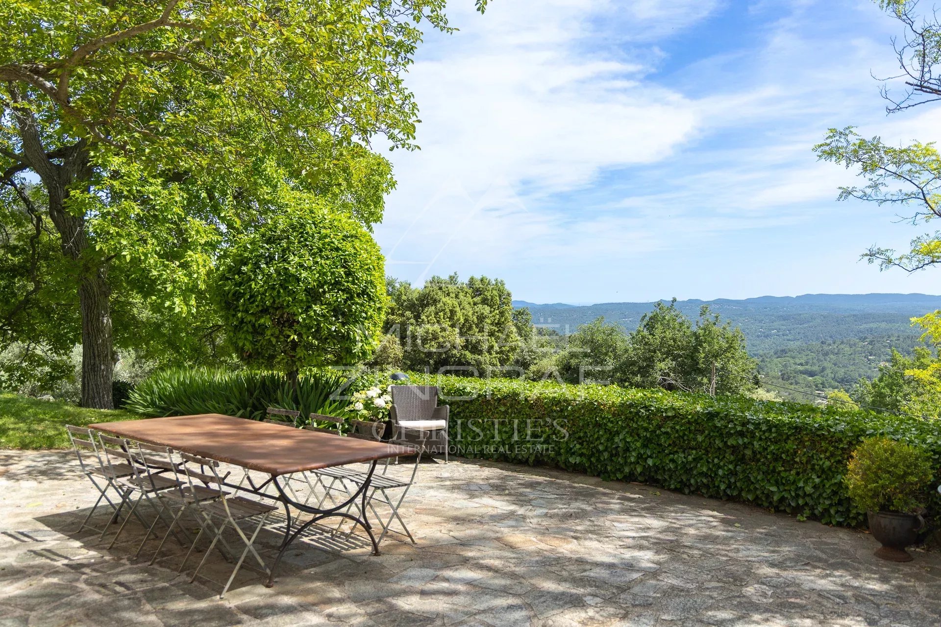Propriété avec vue panoramique à Fayence Terrasse avec table en métal et vue sur la campagne verdoyante à Fayence.