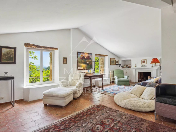 Intérieur lumineux d'une maison avec vue, décoré de meubles modernes et anciens.