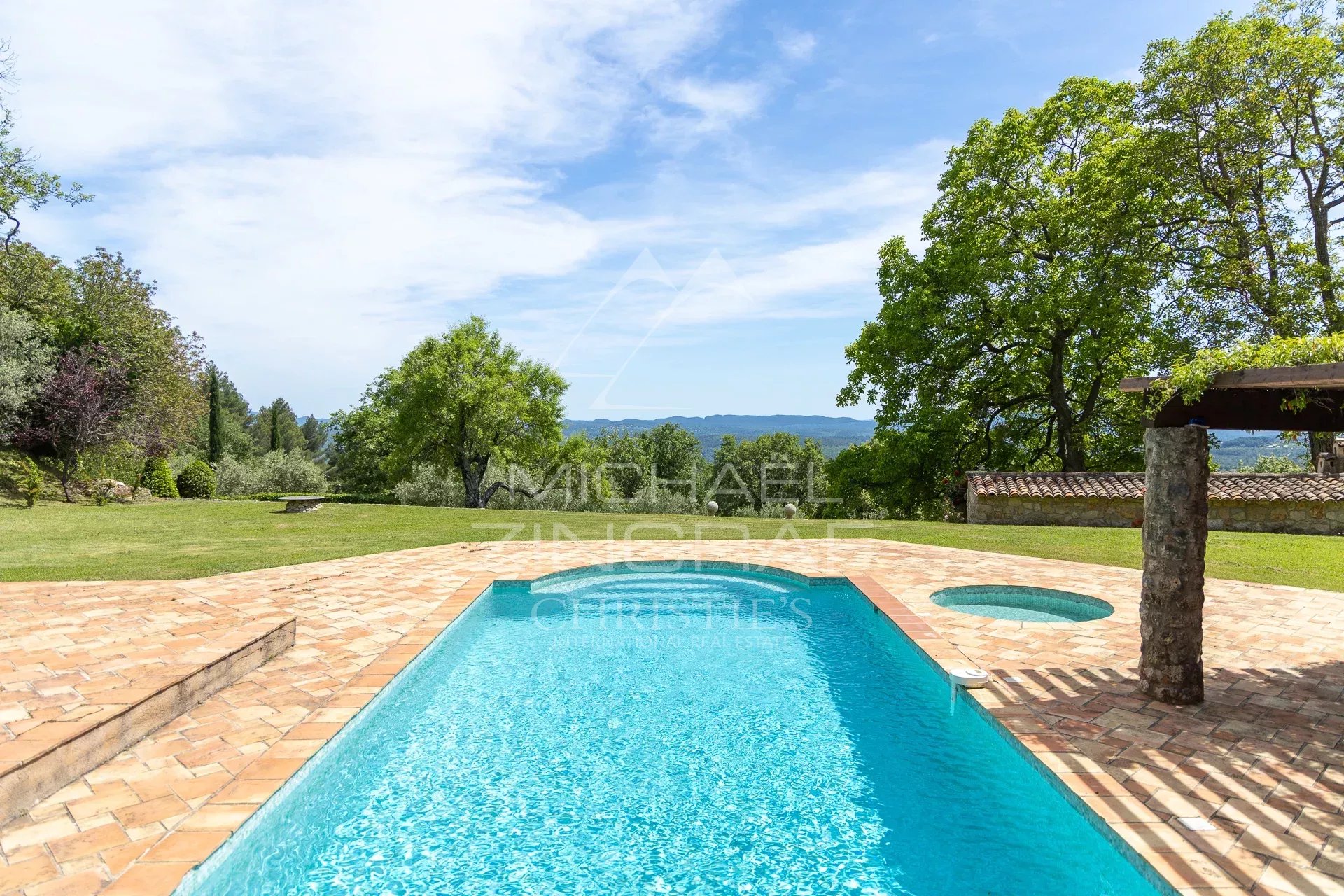 Propriété avec piscine à Fayence Vue d'une piscine avec un espace extérieur verdoyant et des collines en arrière-plan.