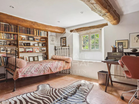 Chambre avec bibliothèque et bureau, décorée de manière authentique, dans une propriété en pierre du XVIIe siècle.