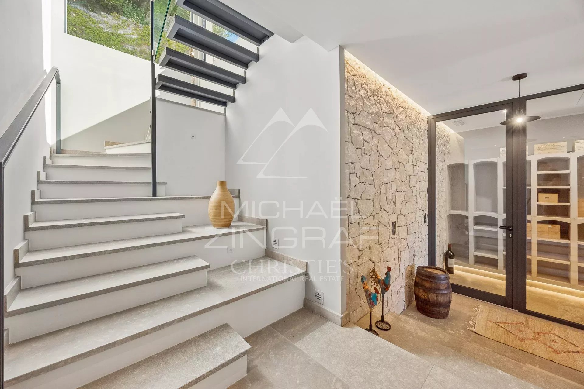 Modern staircase in a villa in Châteauneuf-Grasse Modern stone staircase with glass railings in an elegant villa.