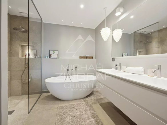 Modern bathroom with bathtub and shower, decorated in neutral tones.