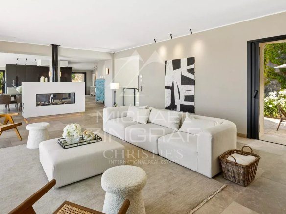 Interior of a modern villa with a bright living room and access to a terrace.