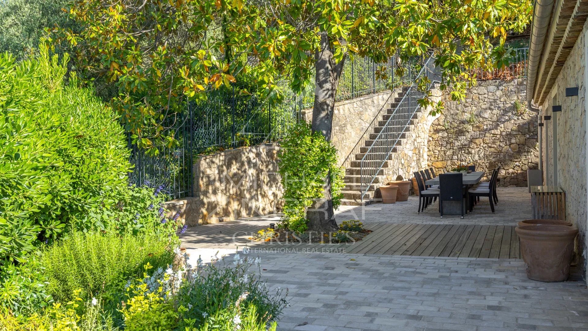 Villa with panoramic views in Châteauneuf-Grasse Terrace of a stone villa with sea views in Châteauneuf-Grasse, surrounded by greenery.