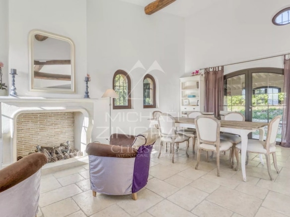 Intérieur d'une villa provençale avec cheminée et coin repas lumineux.