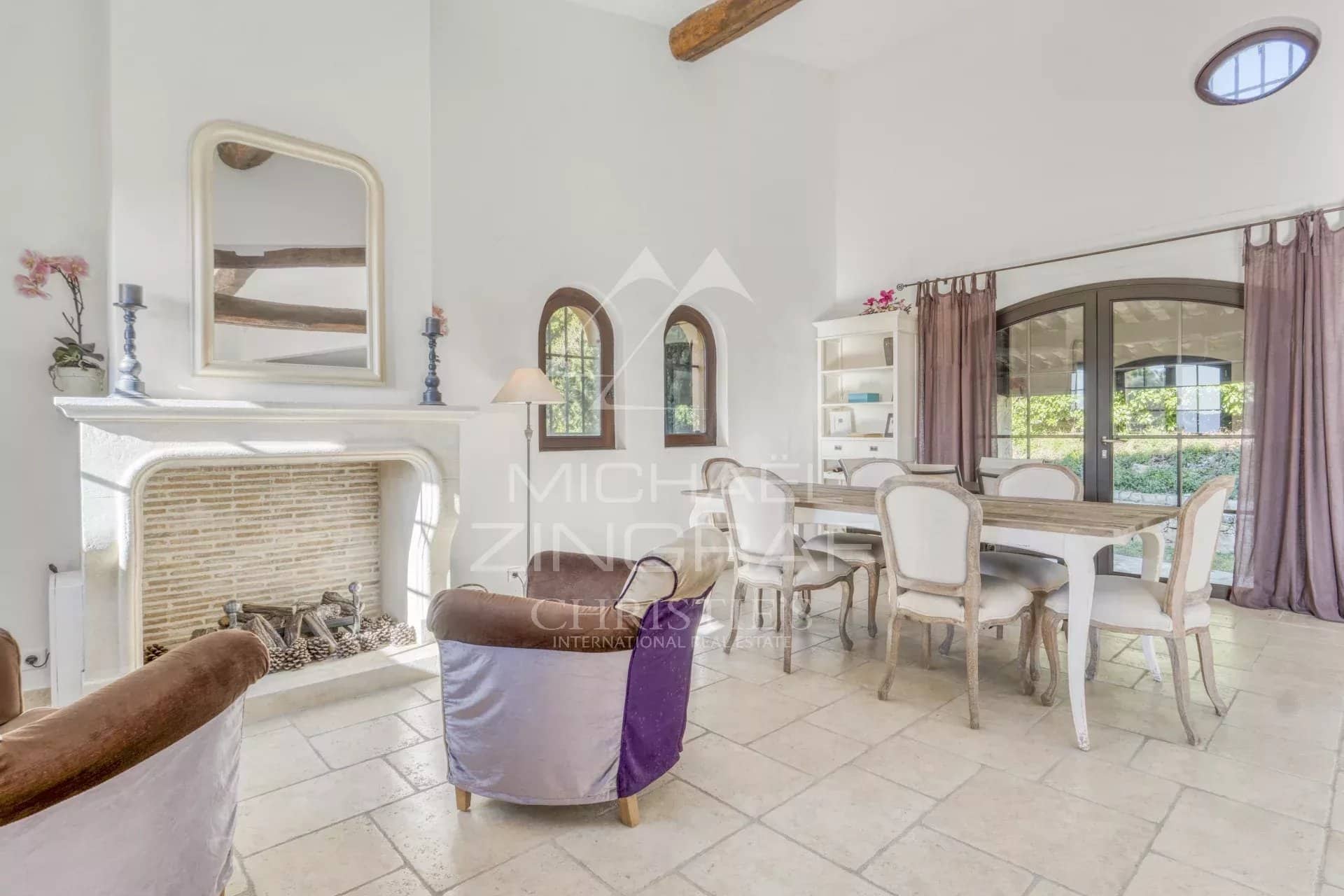 Intérieur d'une villa provençale avec cheminée et coin repas lumineux.