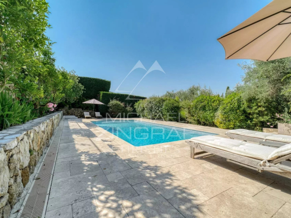 Villa provençale avec piscine et chaises longues dans un jardin verdoyant à Plascassier, Grasse.