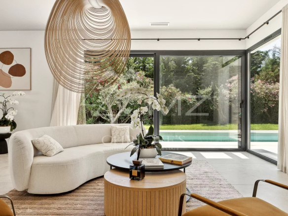 Interior of a contemporary villa with a bright living room and a view of the garden.