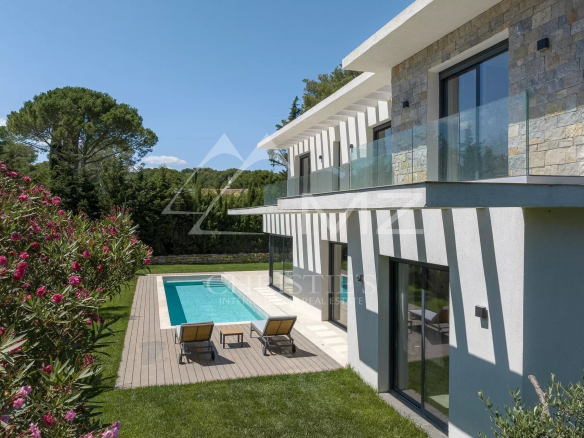 New contemporary villa with swimming pool in Mougins, surrounded by greenery and flowers.