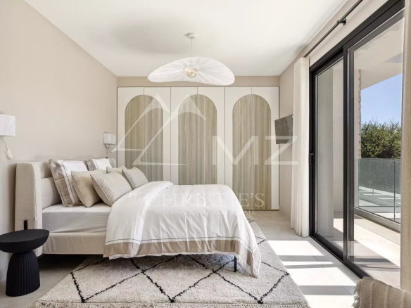 Modern room with bed, minimalist decor and access to a balcony.