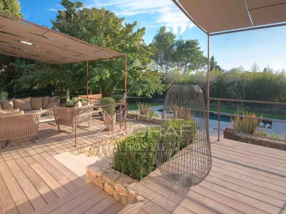 Wooden terrace with modern furniture and a view of a landscaped garden in Mougins.